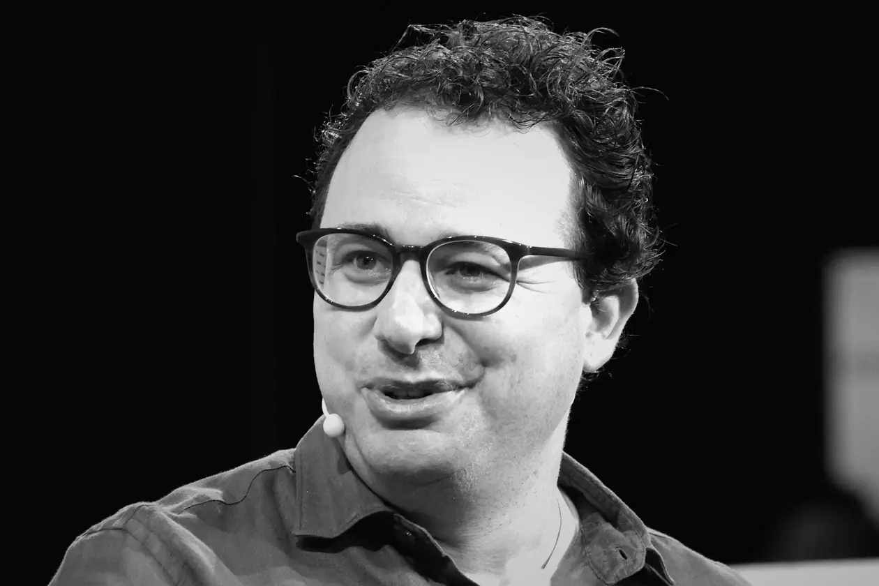 Black-and-white photo of Anthropic CEO Dario Amodei speaking on stage.